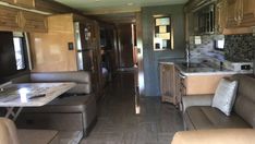 the inside of a travel trailer with couches and kitchen area in front of it