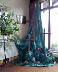 an image of a room with a cross on the floor and plants in the corner