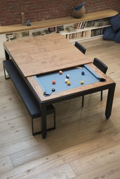 a table with a pool on it in the middle of a wooden floored room