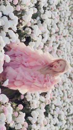 a woman in a pink dress surrounded by white flowers