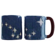 two blue mugs with white stars on them, one is brown and the other is blue