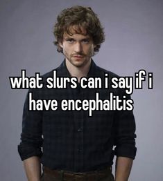 a man with curly hair and beard standing in front of a gray background that says what sl