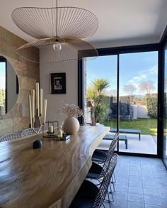 the dining room table is surrounded by black chairs and large glass doors that lead to an outside patio