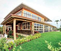 a large house sitting on top of a lush green field