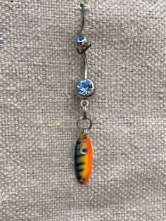 This unique Surgical Steel belly button ring features a VMC Flashcamp Spoon, and a light saphire jewel ball. Perfectly complimenting the women who love to fish and want to make a statement with their body jewelry.  Please note that returns or exchanges on jewelry are not accepted. All California Prop Warnings apply to the jewelry pieces that include fishing lures. #20 Bottom Belly Button Piercing, Unique Belly Rings, Belly Button Piercing Jewelry, Belly Piercing Jewelry, Cool Piercings, Belly Jewelry, Belly Piercing, Belly Button Ring, Belly Button Piercing