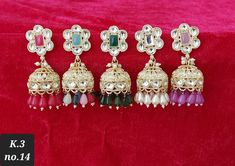 Presenting an exquisite pair of gold-finished dangler earrings adorned with white Kundan polki and colored stones, set delicately in copper. Ideal for festive occasions or wedding ceremonies, these earrings epitomize refined elegance. The additional touch of sophistication is imparted by the matching colored pearls gracefully suspended from the bottom tier, adding an extra layer of grace and allure to the overall design.  Jewelry care instructions : Keep jewelry away from direct heat,water,perfu Elegant Zari Work Danglers For Festivals, Elegant Festival Zari Work Danglers, Elegant Jhumkas With Zari Work For Celebrations, Elegant Zari Work Danglers For Celebration, Elegant Danglers With Zari Work For Celebration, Multicolor Zari Work Earrings For Celebration, Elegant Zari Work Danglers, White Festive Drop Jhumkas, Kundan Jhumka Earrings