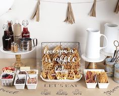 a table topped with lots of different types of food next to cups and saucers