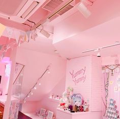 a room filled with lots of pink furniture and decor on top of white shelves in front of a brick wall