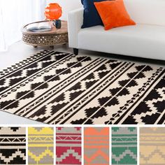 an area rug with different colors and patterns on the floor in front of a white couch