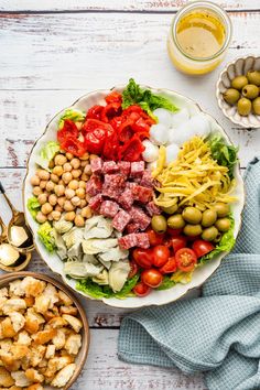 a large salad with meat, tomatoes, lettuce and olives