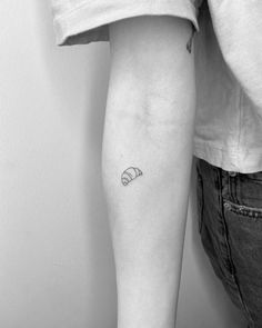 a black and white photo of a person's arm with a small tattoo on it