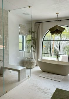 a bathroom with a tub, sink and large window