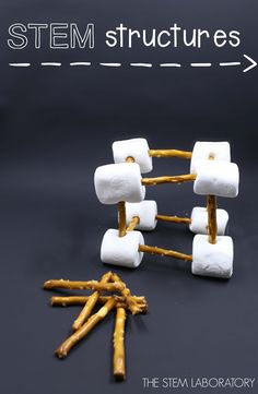 several marshmallows and sticks are arranged in the shape of cubes on a black surface