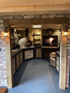 an outdoor kitchen with stone walls and flooring