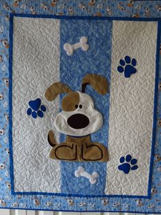 a blue and white quilt with a dog on it's side, paw prints