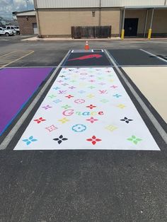 an empty parking lot painted with different colors and designs in front of a business building