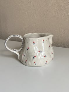 Elevate your table setting with this Handmade Ceramic Pitcher adorned with hand-drawn small flowers. Perfect for serving beverages, this artisanal piece combines functionality with artistic elegance, making it a charming addition to any home. 📍 Product Information: - Lead-free, non-toxic, and food-safe glazes are used - 1 Liters - 34 fl oz - Hand wash recommended. - Resistant to impact and scratches. - Delivered with safe and guaranteed delivery. - Height 12 CM  - The price is for 1 piece pitch Handmade Vases Pottery, Ceramic Vases Handmade, Pitcher Pottery, Vases Handmade, Pitchers Pottery, Pottery Jug, Handmade Vase, Table Vase, Ceramic Pitcher