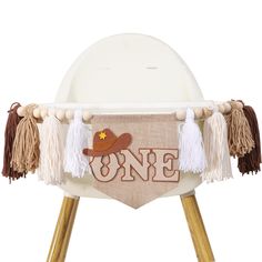 a white chair with some tassels on it and a sign that says one