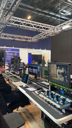 a man sitting at a desk in front of two monitors