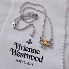 New Never Used, New In Box. This Listing Features A Vivienne Westwood Silver Ribbon Bow With A Gold Signature Logo Orbit Planet In The Center On A Silver Color Chain Necklace. There Is Also A Micro Sized Signature Size Charm At The End Of The Necklace! Bow Pendant Measures 2cm X 1.5cm. Chain Necklace Is Approx 46cm. Comes With Original Box, Dust Bag, Dust Cloth And Care Card. No Receipt. Bundles Welcome For Discounted Shipping. Visit My Page For More Vw Items! No Cancellations! All Sales Are Fin Vivienne Westwood Chain Necklace, Vivienne Westwood Pearl Necklace, Vivian Westwood, Vivienne Westwood Bracelet, Vivienne Westwood Earrings, Vivienne Westwood Jewellery, Bow Pendant, Padlock Necklace, Angel Jewelry