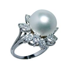 a pearl and diamond ring on a white background