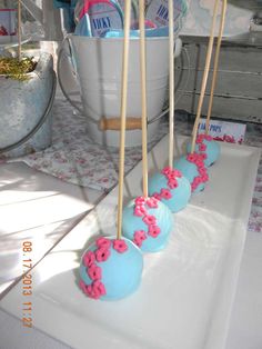 blue cake pops with pink sprinkles on them