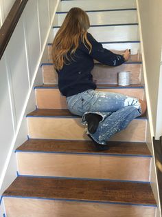 a woman is sitting on the stairs painting