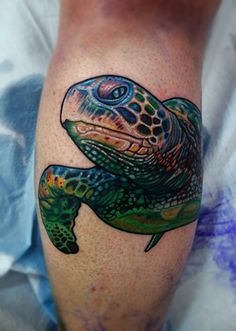 a tattoo on the leg of a person with a turtle on it's arm