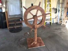 an old spinning wheel is on display in a garage