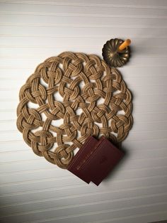 a brown book sitting on top of a wooden table next to a knotted doily