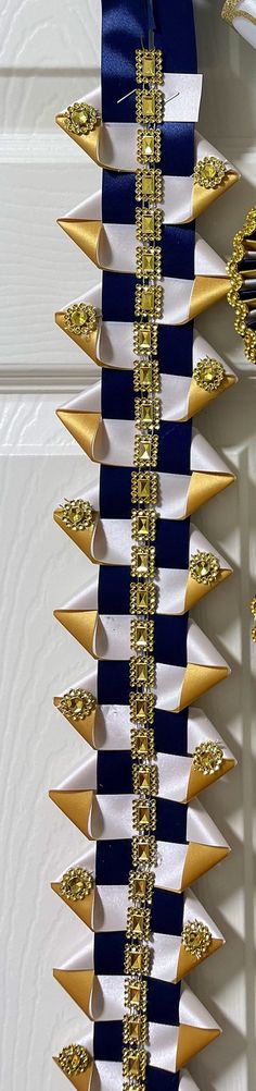 a blue and white striped ribbon with gold spikes on it