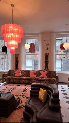 a living room filled with lots of furniture and large chandelier hanging from the ceiling