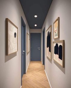 an empty hallway with blue doors and pictures on the wall next to eachother