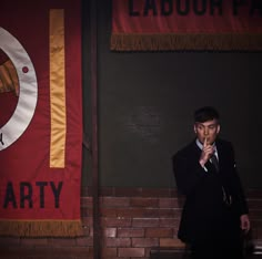 a man standing in front of a red and yellow banner with the words labor party on it