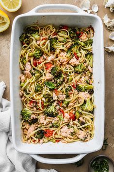 pasta with salmon and broccoli in a white casserole dish on a table