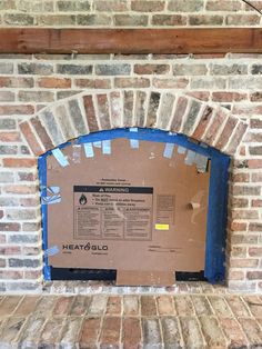 a cardboard box sitting on top of a brick fireplace