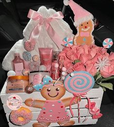 a wooden crate filled with lots of pink and blue items next to a teddy bear