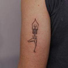 a person with a skeleton tattoo on their arm holding a baseball bat in the air