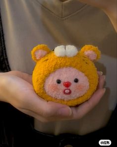 a person holding a small stuffed animal in their hands