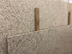 two wooden handles on the side of a wall with granite walls and flooring in an office building