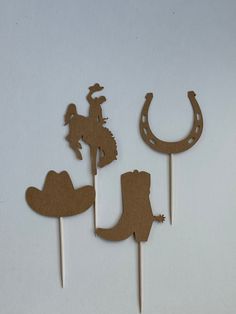 three cupcake toppers made to look like cowboy hats and boots