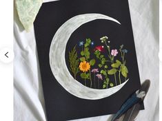 an image of a painting with flowers and leaves in the shape of a half moon