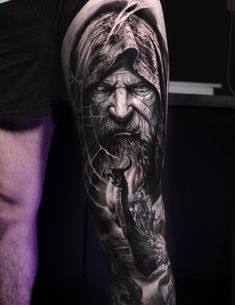 a man's leg with tattoos on it and an image of a wizard in the background