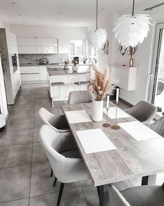 a dining room table with chairs and a vase on it