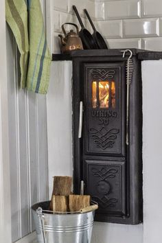 an old fashioned stove in the corner of a kitchen with utensils on it