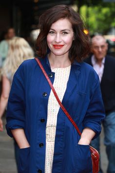 a woman standing on the street with her hands in her pockets