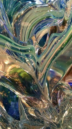 an abstract glass sculpture with wavy lines and colors