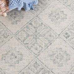 an overhead view of a blue and white rug with a basket on the floor next to it