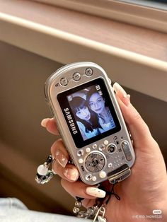 a person holding a cell phone in their hand and looking at the screen with an image on it