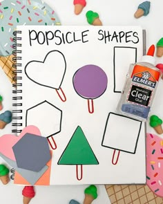 an open notebook with popsicle shapes on it next to some ice cream cones and sprinkles